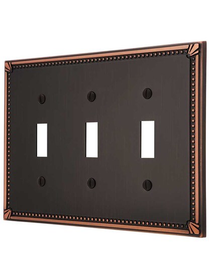 Imperial Bead Triple Toggle Switch Plate in Aged Bronze.